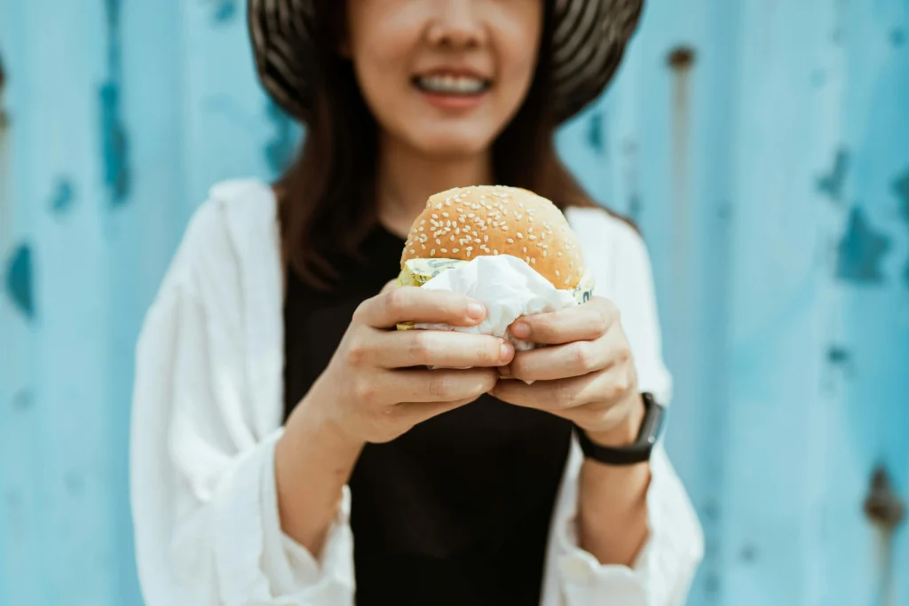 Person holding a burger while entering a Burger King gift card giveaway in the UK